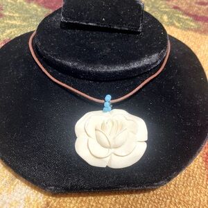 White rose on leather cord necklace.